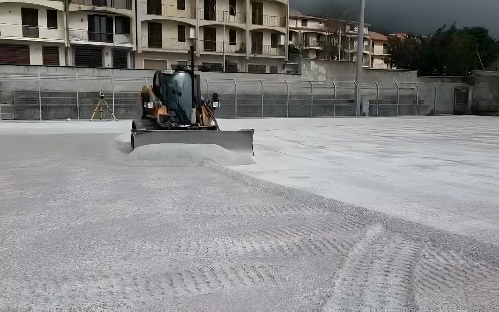 Mezzo al lavoro sul campo con tribuna sullo sfondo
